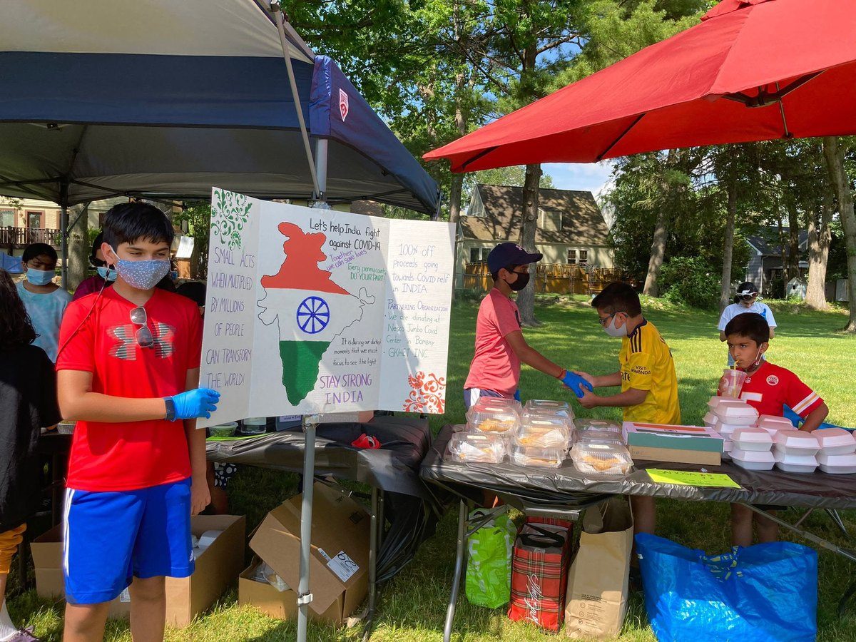 A volunteer at the first bake sale with a hand painted poster